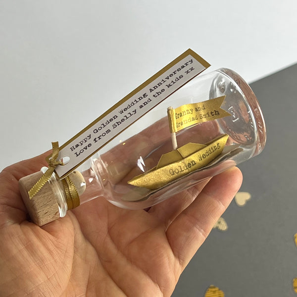 golden wedding anniversary personalised boat in a bottle in hand
